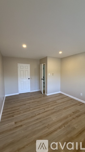 A room with wooden flooring and a white door.
