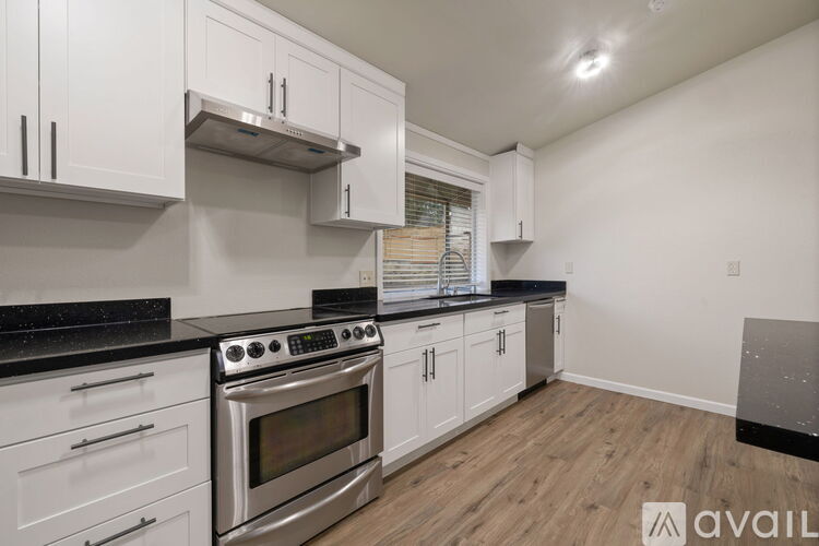 A kitchen with white cabinets and a stainless steel oven.