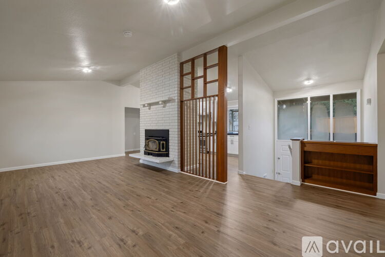 A spacious living room with a fireplace and wooden flooring.