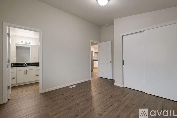 A spacious room with wooden floors and white walls.