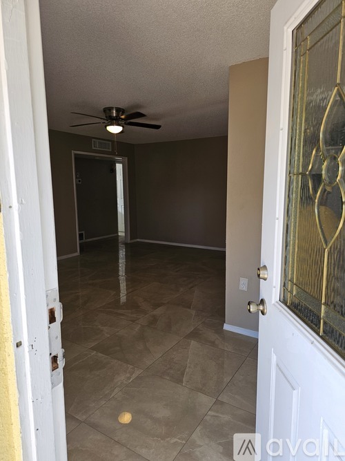A room with a ceiling fan and a door.
