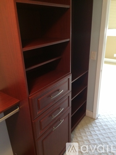 A brown wooden shelf with drawers and a white door in the background.