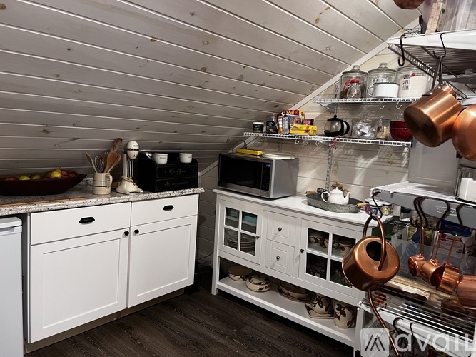 A kitchen with white cabinets and a lot of cooking utensils.