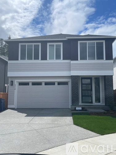 A two-story house with a garage door and a front door.
