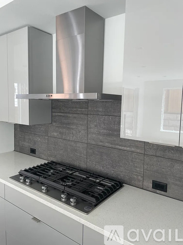 A modern kitchen with a stove top oven and a range hood.