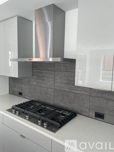 A modern kitchen with a stove top oven and a range hood.