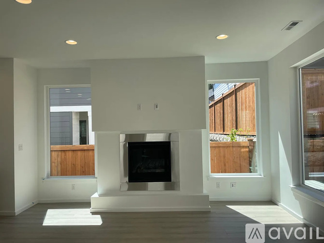 A modern living room with a fireplace and a large window.