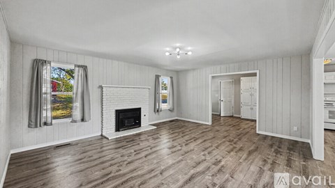 A spacious living room with a fireplace and hardwood floors.
