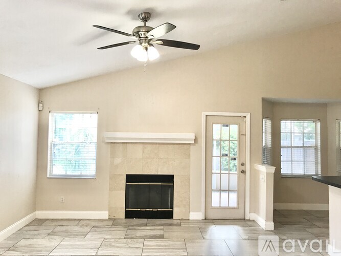 A living room with a fireplace and a ceiling fan.