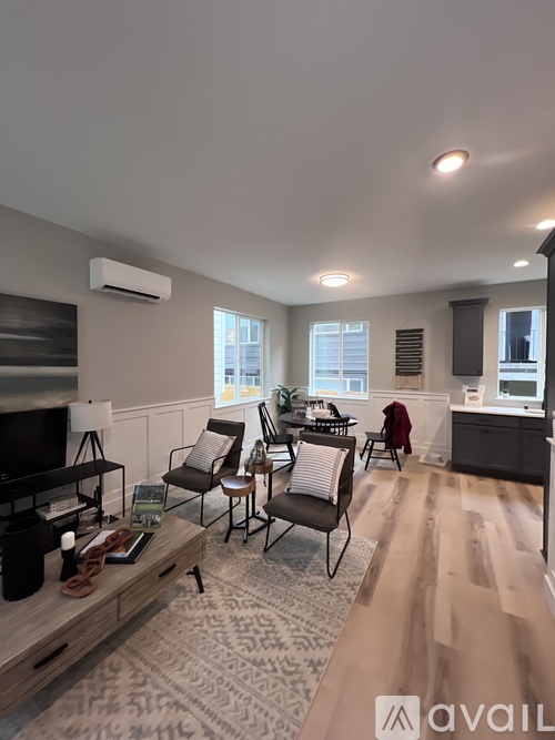 A living room with a television, chairs, and a coffee table.