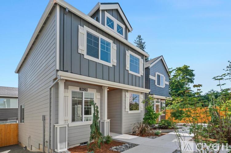 A modern house with a grey exterior and a white door.