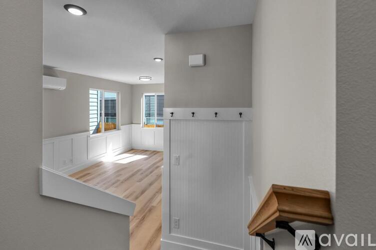 A modern interior space with a wooden floor and white walls.