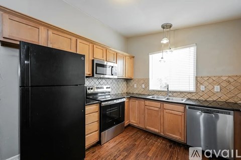 A kitchen with black appliances and wooden cabinets.