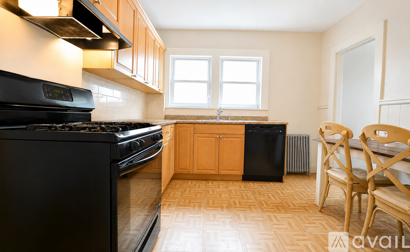 A kitchen with black appliances and wooden cabinets.