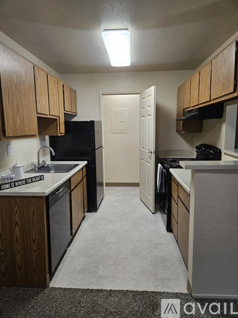 A kitchen with wooden cabinets and black appliances.