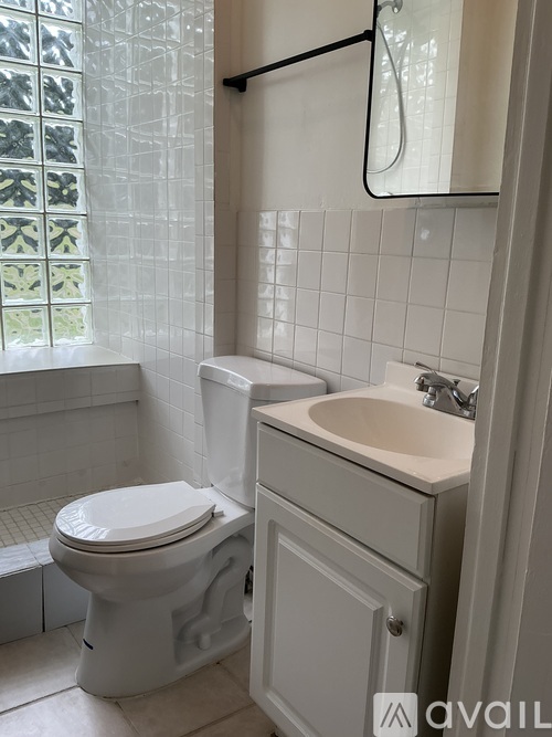 A white toilet sits next to a sink in a bathroom.