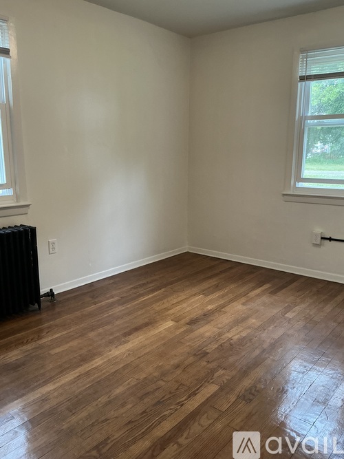 A room with wooden flooring and a window.