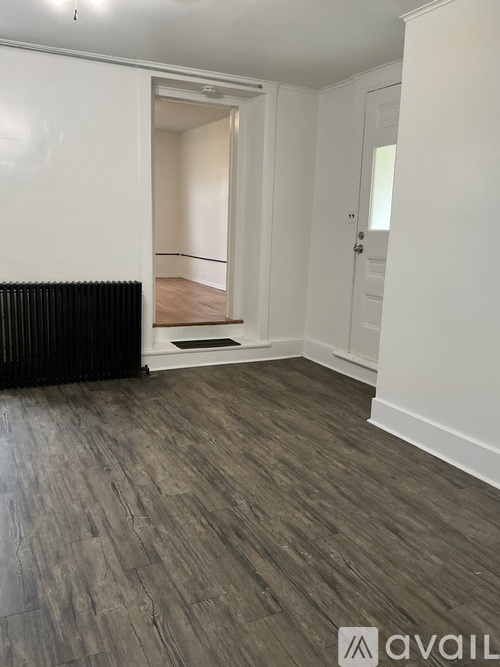 A room with a wooden floor and white walls.