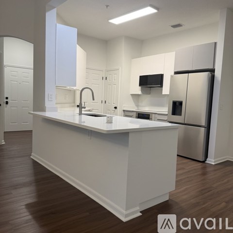 A kitchen with white cabinets and a white island.