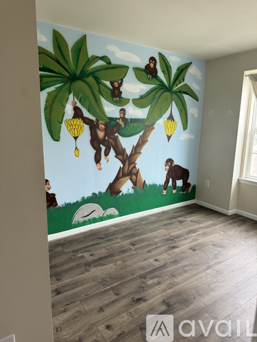 A wall mural of monkeys hanging from trees.