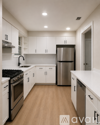A kitchen with white cabinets and stainless steel appliances.