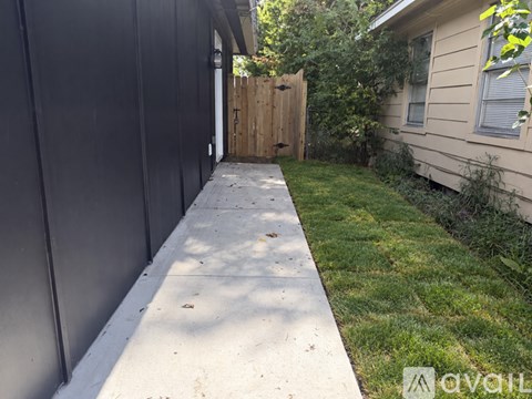 A concrete pathway leads to a wooden gate.