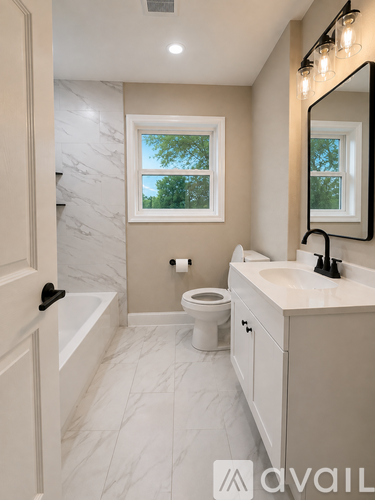 A bathroom with a toilet, sink, and mirror.