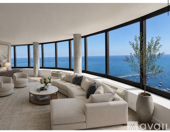 A living room with a view of the ocean through large windows.