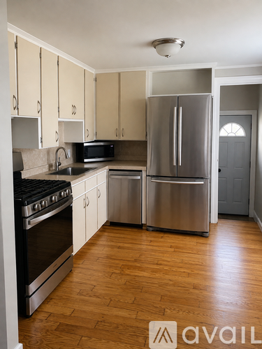 A kitchen with wooden floors and stainless steel appliances.