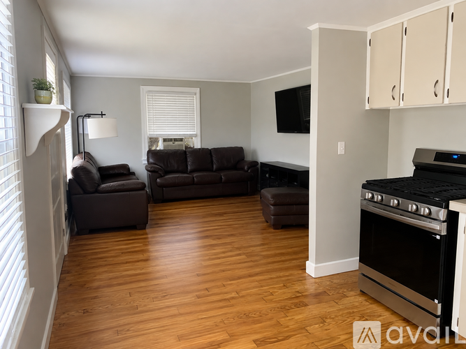 A living room with a black couch and a television.