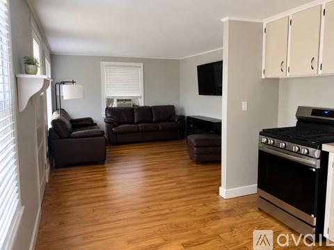 A living room with a black couch and a television.