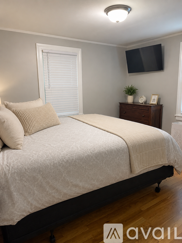 A bedroom with a bed, nightstand, and window.