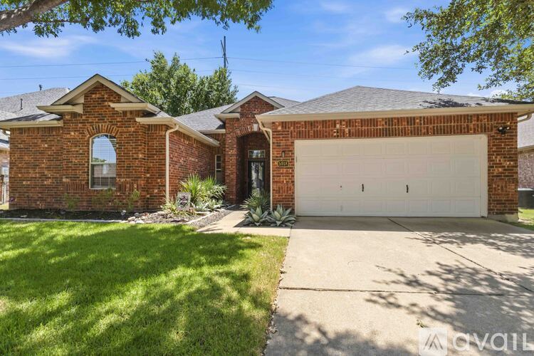 A house with a brick facade and a white garage door is for sale.