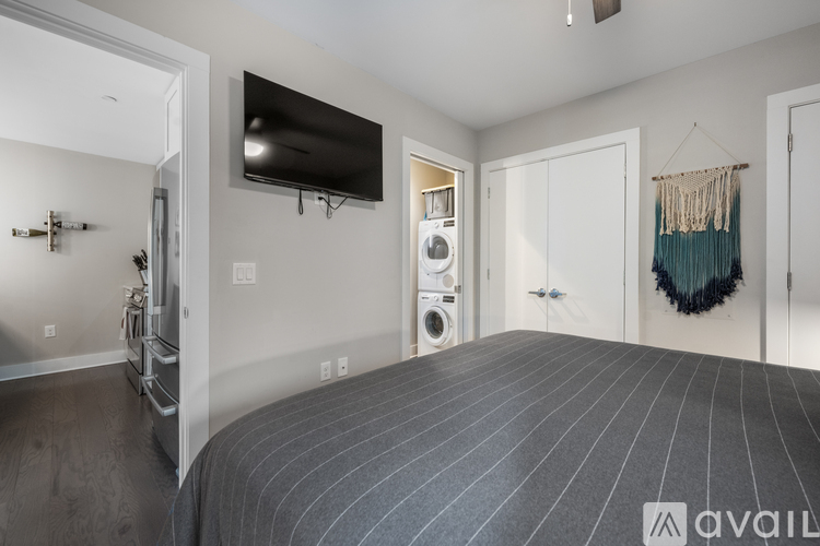 A bedroom with a large bed and a flat screen TV mounted on the wall.