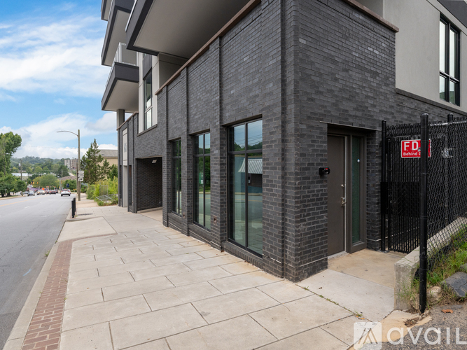 A modern building with a black fence and a red sign on it.