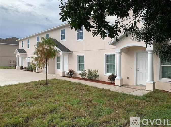 A beige house with a white door and windows.