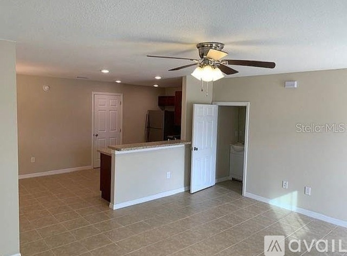 A spacious room with a ceiling fan and a reception desk.