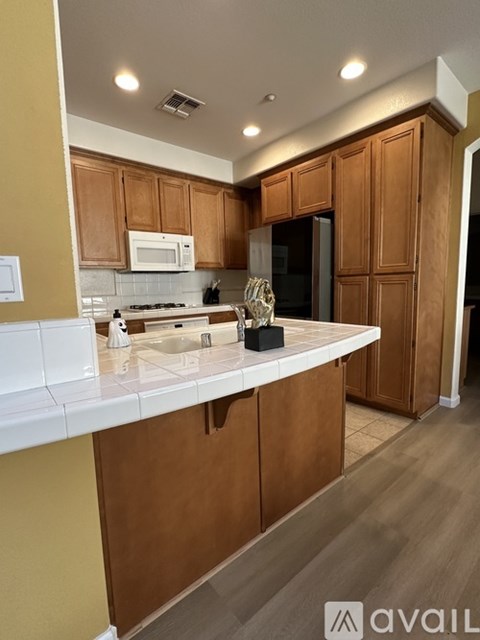 A kitchen with wooden cabinets and a white countertop.