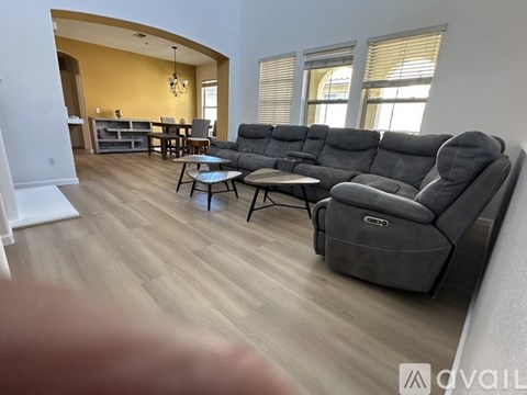 A living room with a grey sofa and a glass coffee table.
