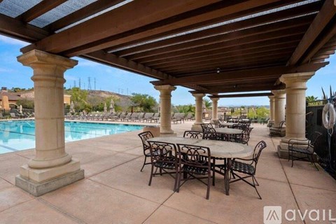 A patio with a pool and a table set up for dining.