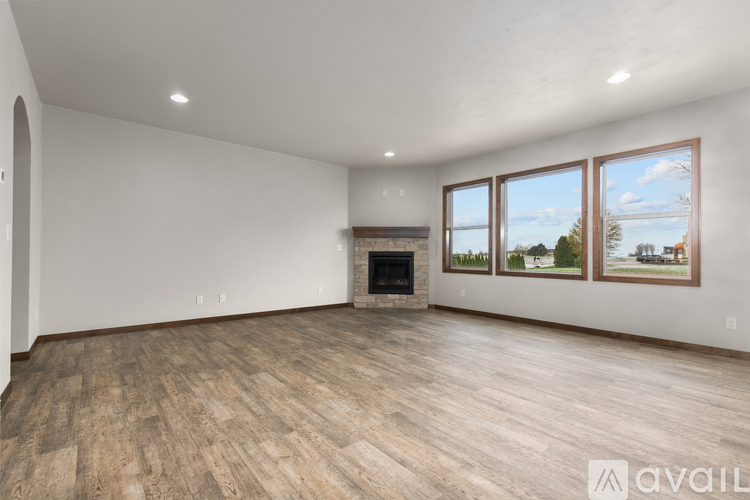A spacious living room with a fireplace and wood flooring.