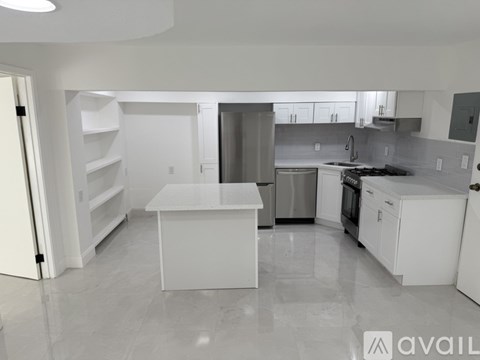 A kitchen with white cabinets and appliances.
