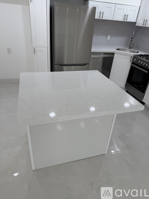 A kitchen with a white island in the middle.