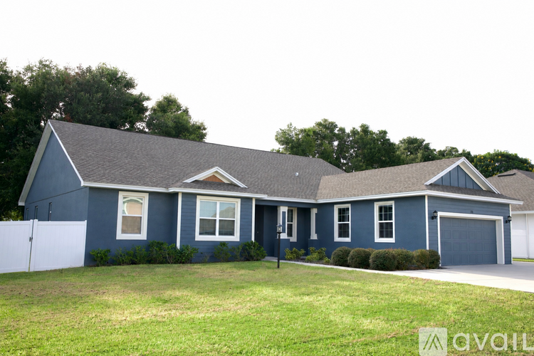 A blue house with a white fence in front.