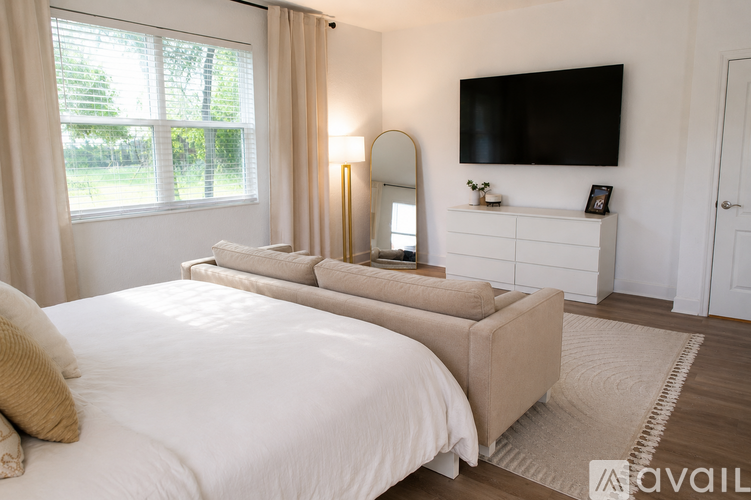 A bedroom with a large bed and a flat screen TV mounted on the wall.