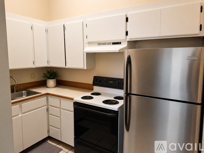 A kitchen with white cabinets and a stainless steel refrigerator.