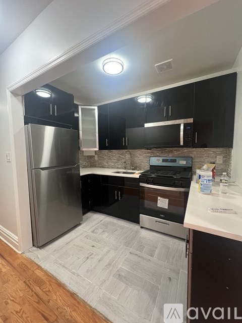 A kitchen with a refrigerator, oven, and microwave.