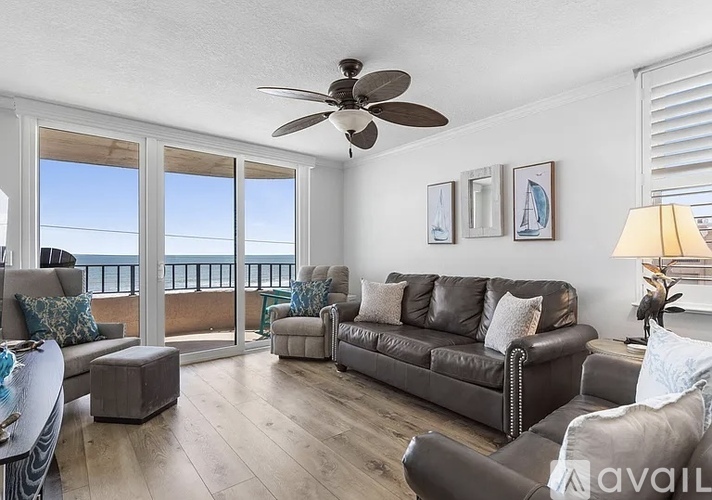 A living room with a large window overlooking the ocean.