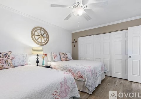 A bedroom with two beds and a ceiling fan.