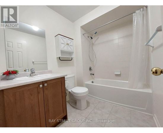 A white bathroom with a toilet, sink, and bathtub.